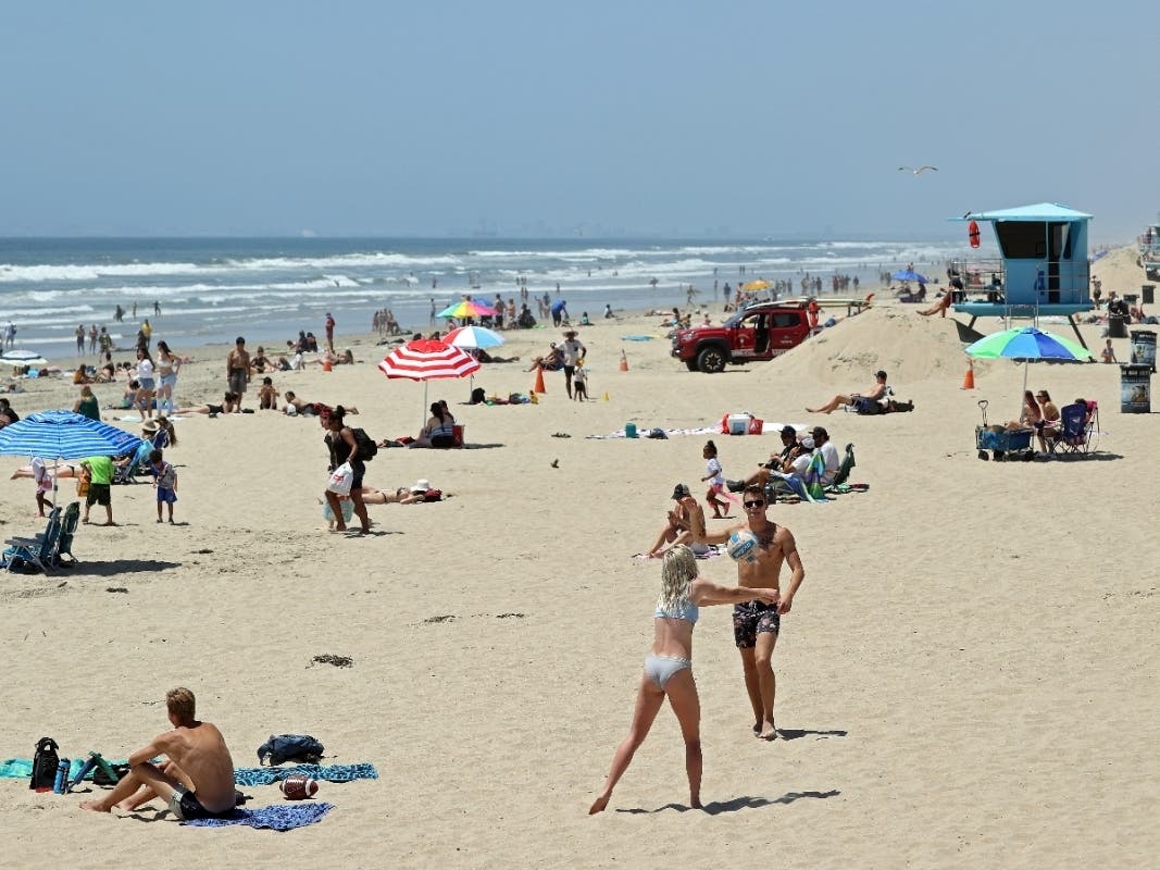 People gather at the beach amid the coronavirus pandemic on May 15, 2020 in Huntington Beach, California.