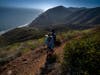 A couple hike through the mountains close to Point Mugu as hiking paths reopen on May 23, 2020 in Ventura County, California. Picnics and groups are still banned and many people are wearing masks