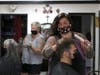 Hair stylists Angie Redmond (2L) and Kayla Van Dyke (2R) give haircuts to Tandi Blonigen (L) and Todd Maltbie (R) at The Parlor on May 27, 2020 in Napa, California.