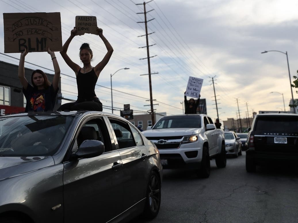 Protesters ride atop cars during a peaceful demonstration over George Floyd’s death in the Hollywood area on June 2, 2020 in Los Angeles, California.
