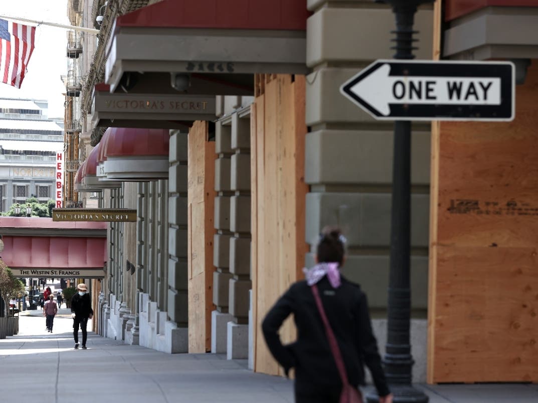 Pedestrians walk by boarded up businesses on June 11, 2020 in San Francisco, California.
