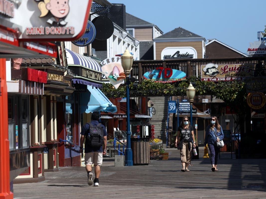 Visitors walk along tourist destination Pier 39 on July 09, 2020 in San Francisco, California. San Francisco tourist attractions are struggling to stay afloat as the coronavirus COVID-19 pandemic continues.