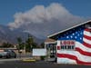Smoke from the Apple Fire is seen behind a stars and stripes painted building in the community of Calimesa on August 2, 2020 near Cherry Valley, California.
