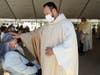 Newly ordained priest Filiberto Cortez, originally from Mexico, gives a first blessing to a family member during the first-ever outdoor Ordination Mass at the Cathedral of Our Lady of the Angels amid the COVID-19 pandemic on August 8, 2020 in Los Angeles,