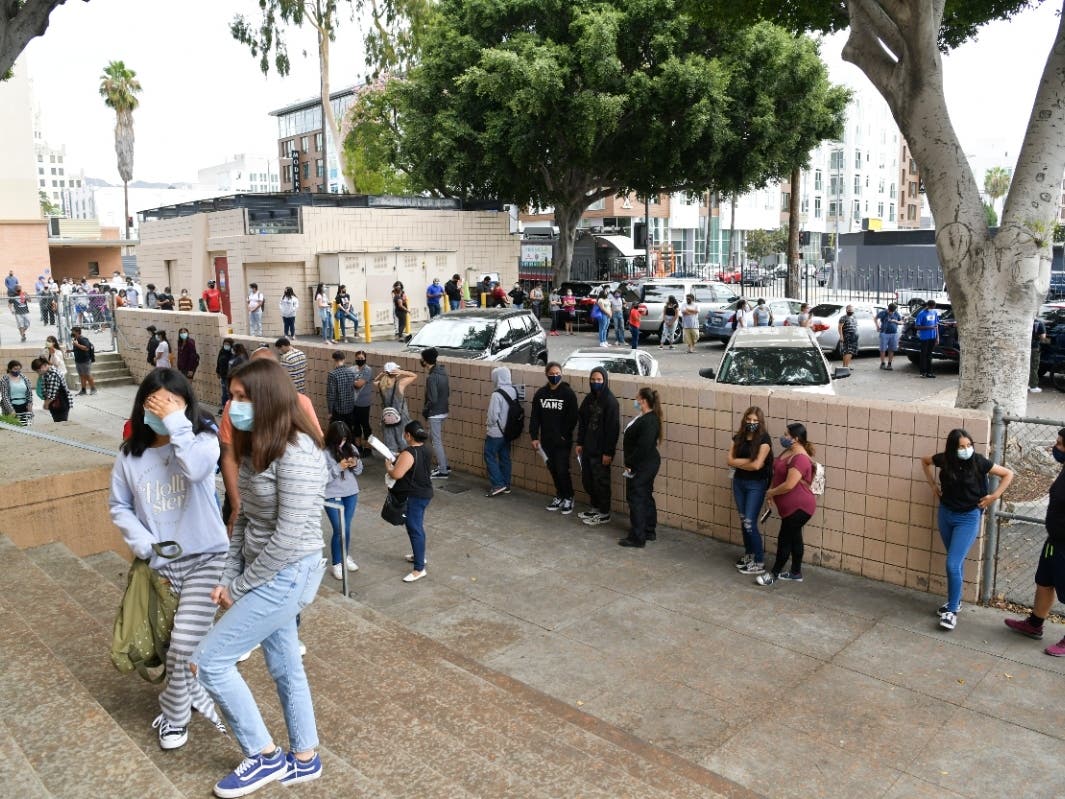 Students wait in line to pick up school resources at Hollywood High School on August 13, 2020 in Hollywood, California. With over 734,000 enrolled students, the Los Angeles Unified School District is the largest public school system in California.