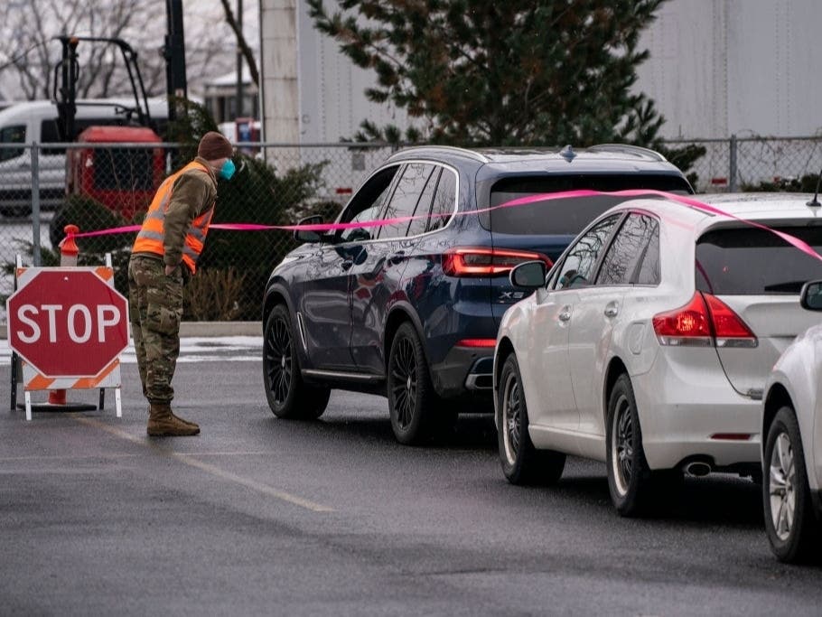 A member of the Washington National Guard checks on patients who have just received a COVID-19 vaccine and are waiting in an observation area at Town Toyota Center on Jan. 26, 2021 in Wenatchee, Wash.