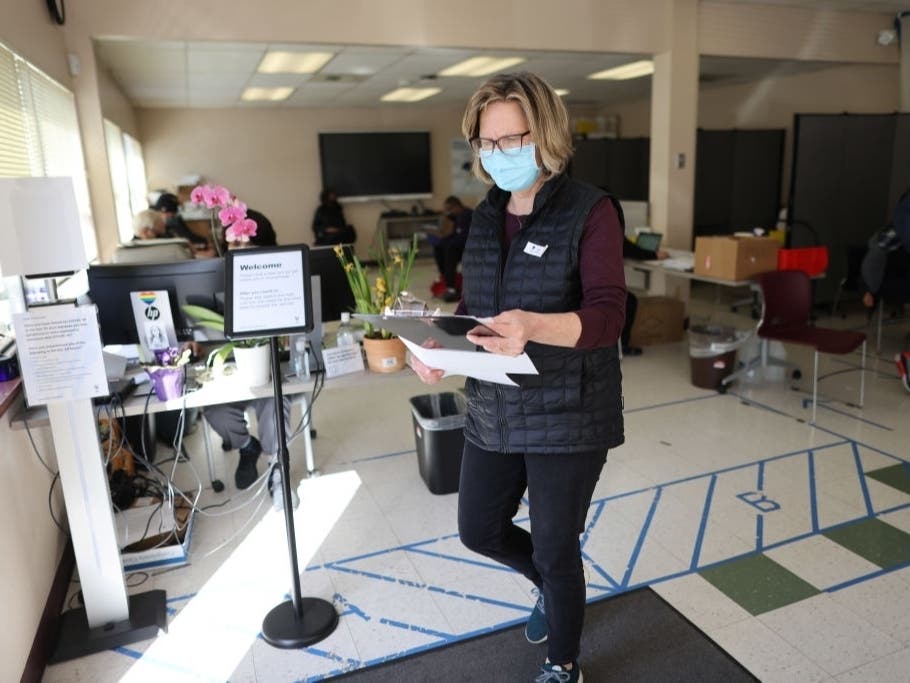 Hilary Stephens from Seattle Public Schools Health Services helps manage the flow of people coming in for Covid-19 vaccinations at the Seattle Indian Health Board on March 15, 2021, in Seattle.