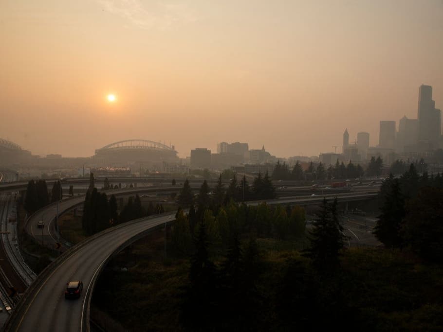 Cars drive on I-5 in front of a hazy Seattle skyline due to wildfire smoke on Sept. 11, 2020, in Seattle.