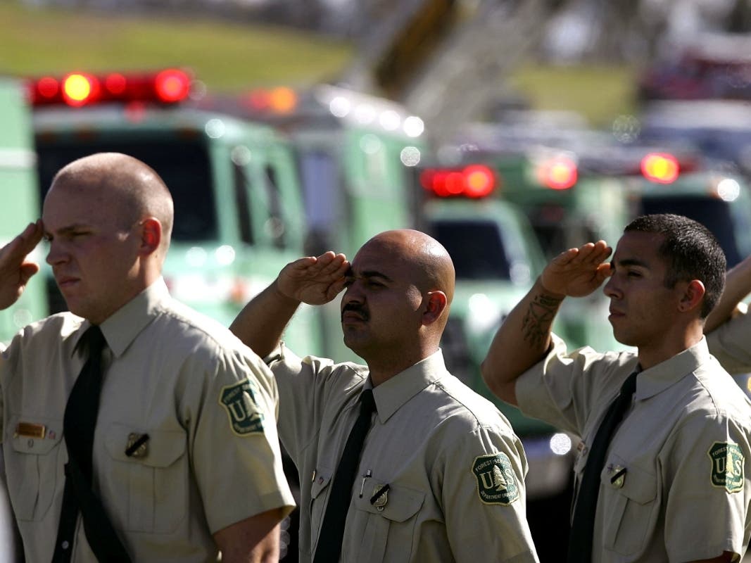 USFS firefighters salute the procession of fellow firefighters and family members arriving for the memorial service for five U.S. Forest Service firefighters on November 5, 2006 in San Bernardino.