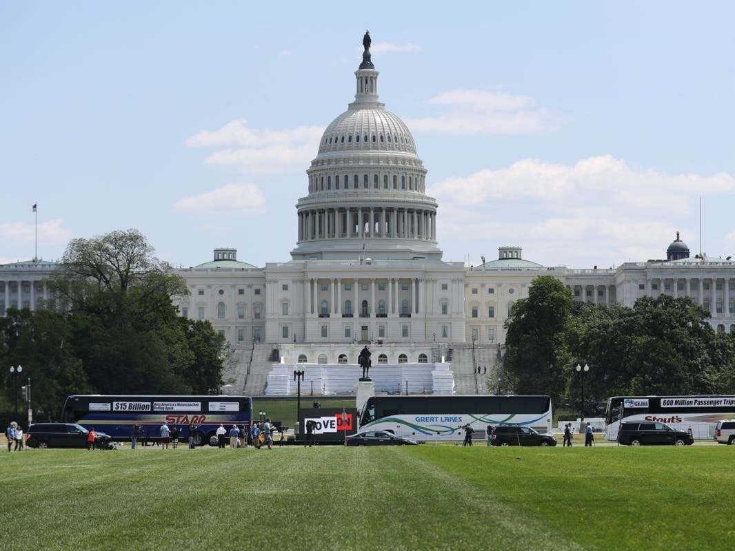 Motorcoaches representing companies from across the country drive past the U.S. Capitol building Thursday as they do laps around the National Mall to protest the economic impact the novel coronavirus pandemic is having on their business.