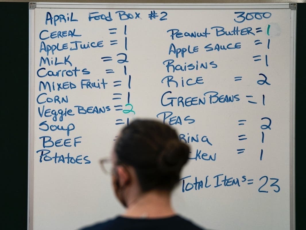 A whiteboard displays how much of each food to include as volunteers pack up boxes of food to be distributed to those in need at the distribution center of the Capital Area Food Bank on April 9, 2020 in Washington, D.C. 