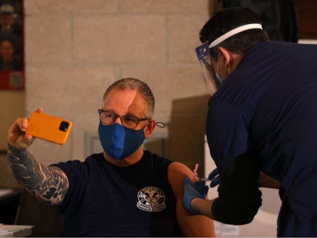 A member of FDNY EMS takes a selfie as he receives the coronavirus vaccine on Wednesday.
