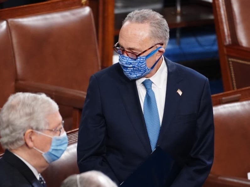 Senate Minority Leader Chuck Schumer, at right, stands with Senate Majority Leader Mitch McConnell as they attend the Electoral College vote certification for President-elect Joe Biden