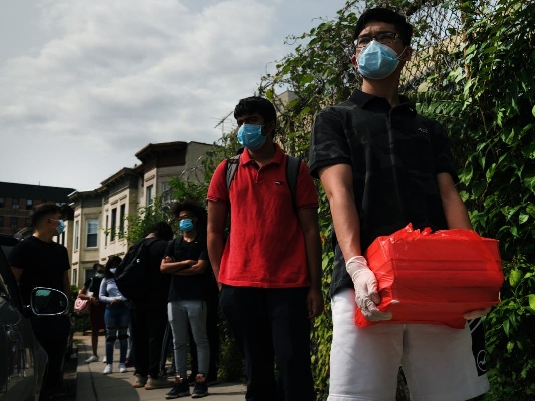 Seniors at a Brooklyn High School wait in line to return books and get their schedules for the year on Sept. 14.