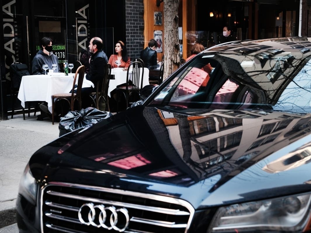 People eat along the sidewalk at a restaurant in a wealthy part of Manhattan on April 6.