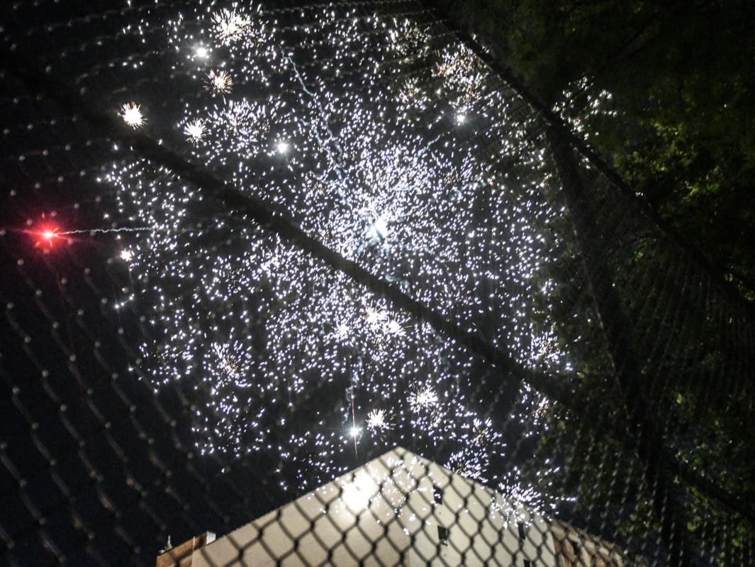 A person records with a phone a fireworks display in an empty park on June 24, 2020 in Brooklyn.