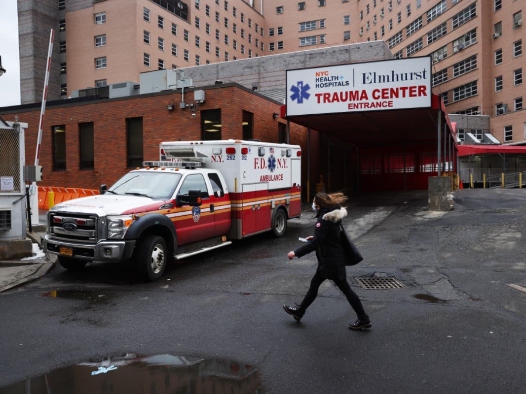 A person walks by a hospital in a neighborhood among those that have seen some of the highest number of city Covid-19 deaths on Feb. 23 in Queens.