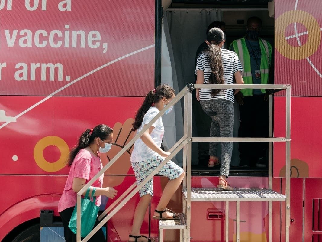 A family enters a pop-up COVID-19 vaccine site on June 5 in Jackson Heights.