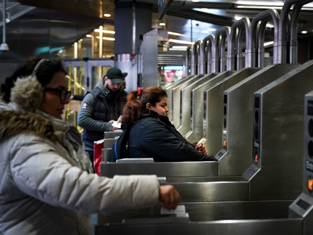 Customers swipe their metro cards as they move through the turnstiles at the Fulton Center subway station on Feb. 27, 2019.