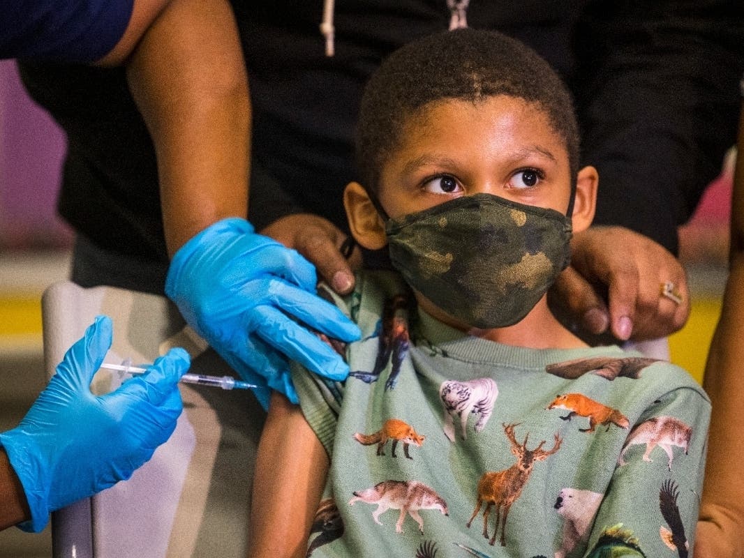 Christopher Reyes, 9, sits silently as he is administered the coronavirus vaccine at a vaccination pop-up site at P.S. 19 on Monday on the Lower East Side.