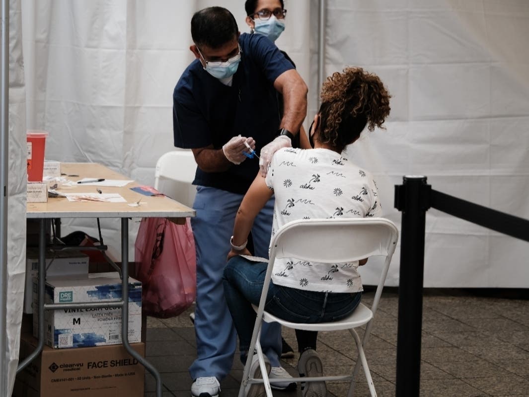 People receive a COVID-19 vaccination shot at the Broadway Junction subway station in Brooklyn on May 12.