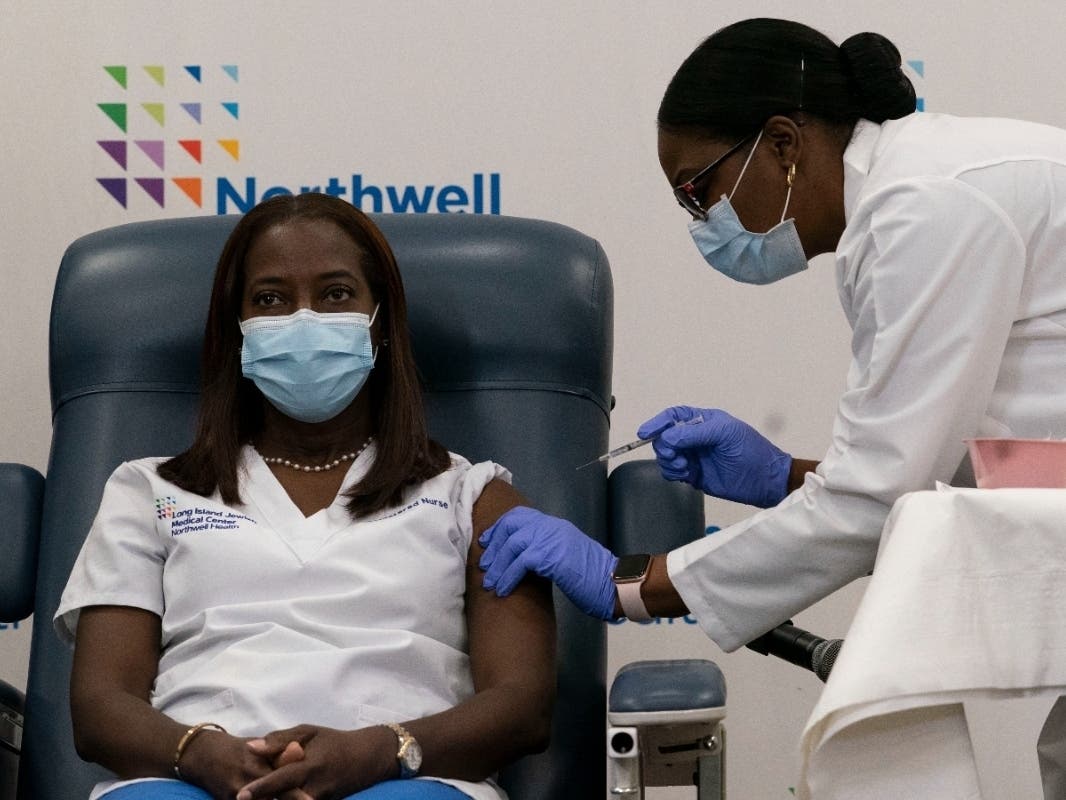 Sandra Lindsay, left, a nurse at Long Island Jewish Medical Center, is inoculated with the COVID-19 vaccine by Dr. Michelle Chester on Dec. 14, 2020, in Queens.