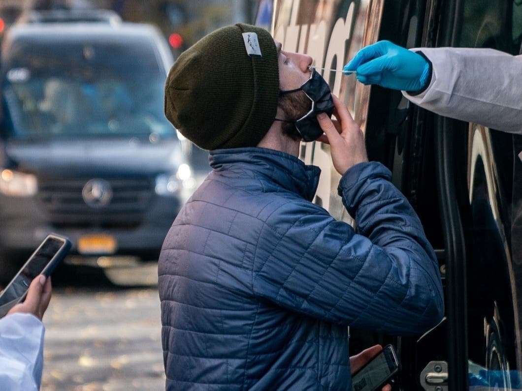 A person has a COVID-19 test administered at a walk-up testing site on Dec. 15.