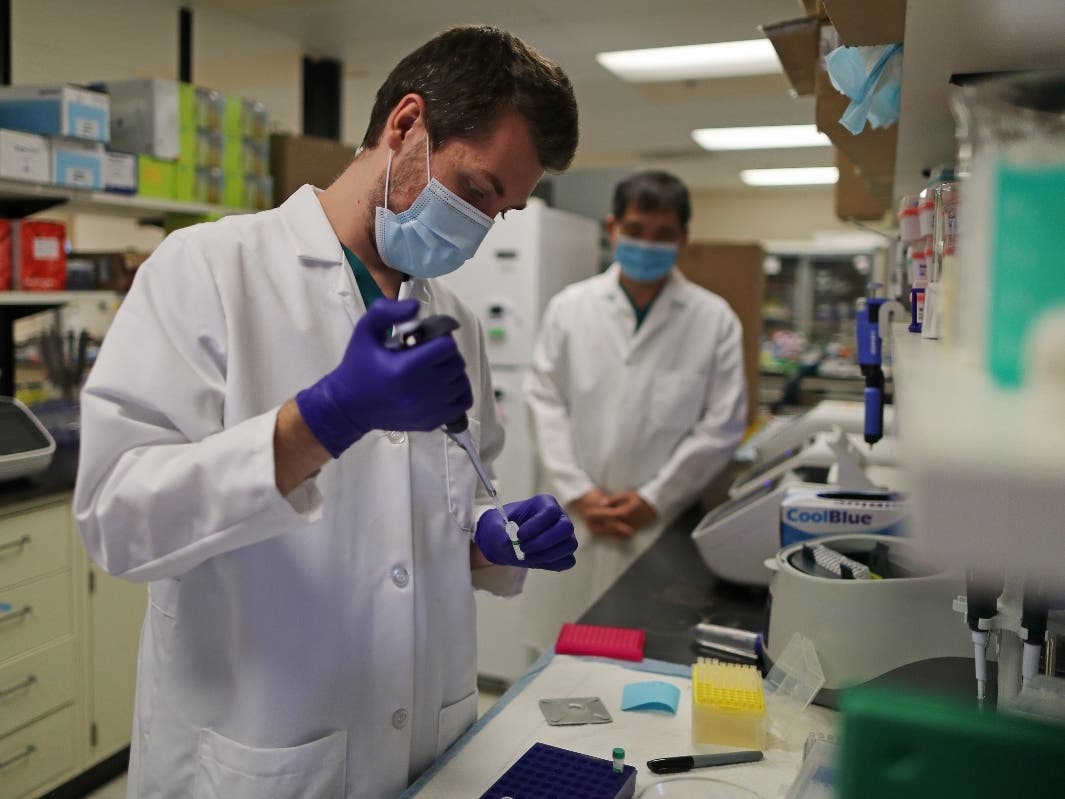 Lab Technicians in Rockville, Maryland prepare a solution that will be used to process coronavirus test samples.