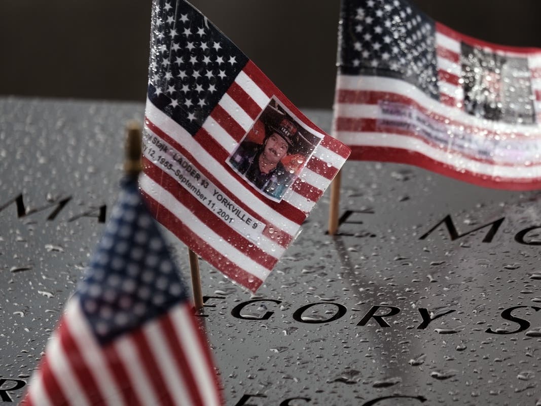 Pictures of fallen firefighters are placed on their names at the September 11th Memorial in New York City.