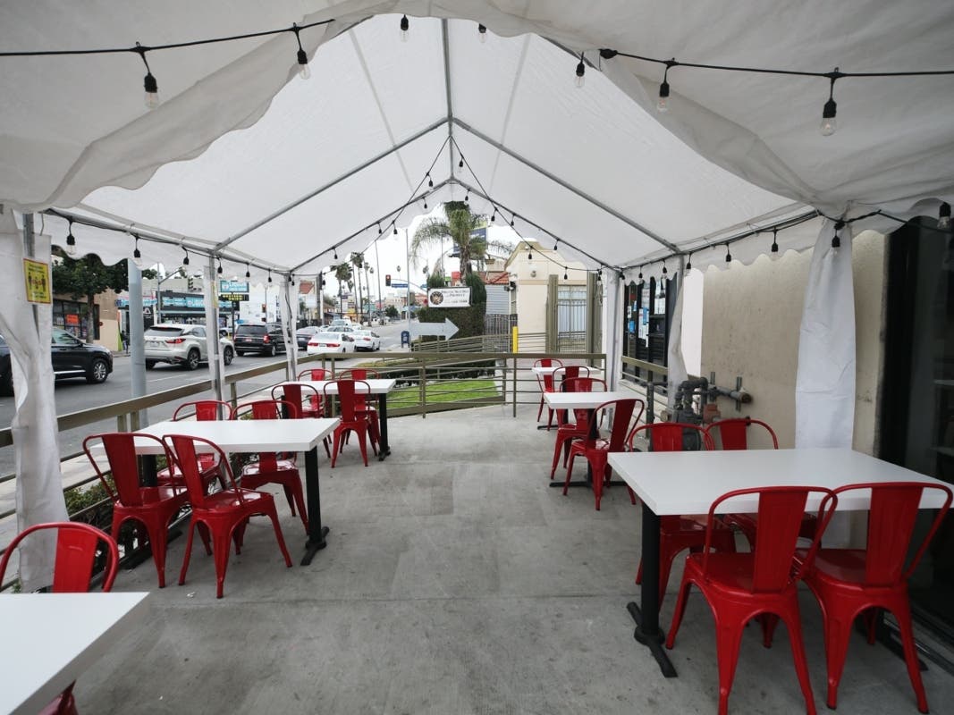 LOS ANGELES, CALIFORNIA - DECEMBER 07: A tented area for outdoor restaurant dining stands empty on the first day of new stay-at-home orders on December 7, 2020 in Los Angeles, California. 