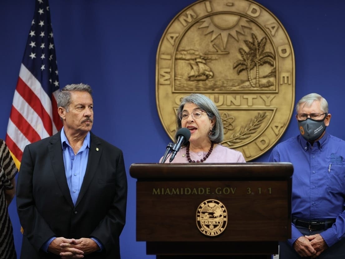 Miami-Dade Board of County Commissioners Chair Jose “Pepe” Diaz, left, appears at a news conference on hurricane preparedness with Miami-Dade County Mayor Daniella Levine Cava, center, June 1. Diaz and his chief of staff have tested positive for COVID-19.