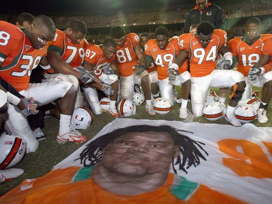 University of Miami teammates of Bryan Pata, who was shot and killed 15 years ago, pray over a mural that was placed at mid-field after defeating Boston College at the Orange Bowl Stadium in Miami Nov. 23, 2006. Rashaun Jones was charged with his murder.