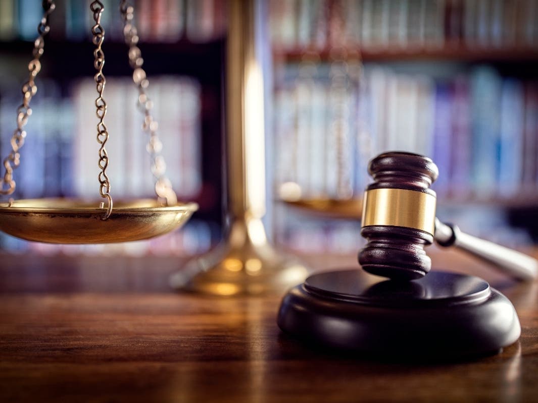 A file photo of a gavel, scales of justice, and law books.