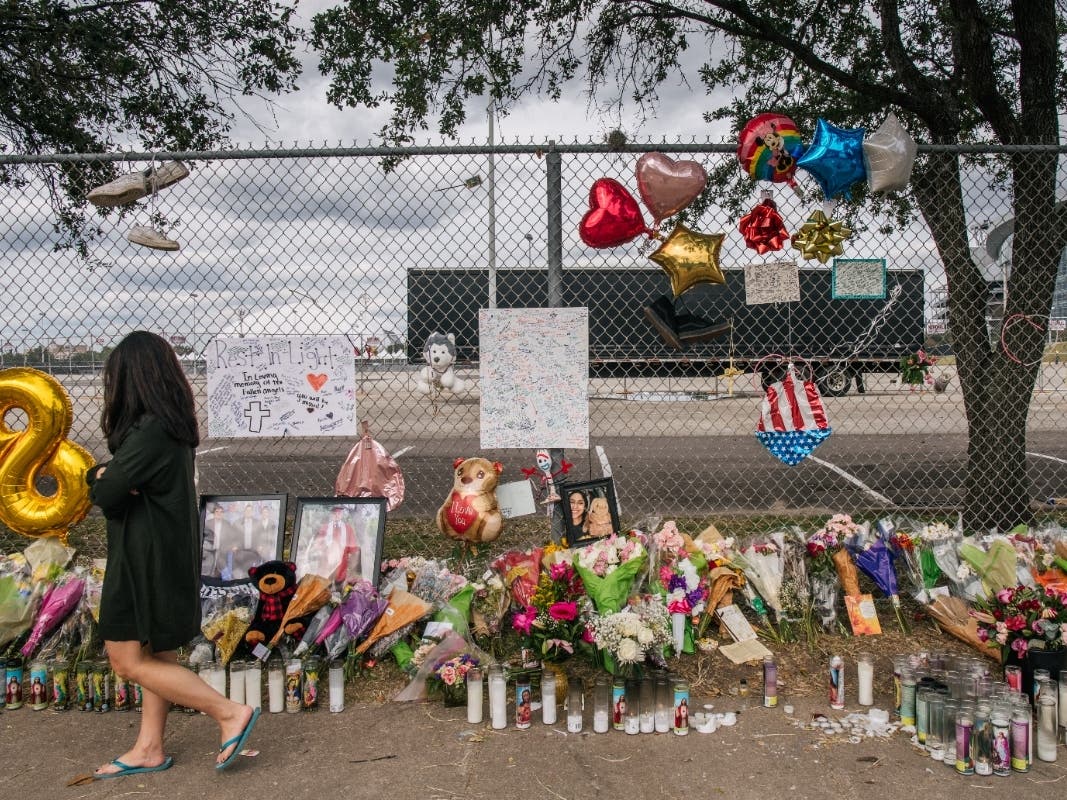 A woman walks past a memorial to those who died at the Astroworld festival outside of NRG Park on Tuesday in Houston. Texas A&M student Bharti Shahani died Wednesday evening, bringing the death toll of the incident to nine people. 