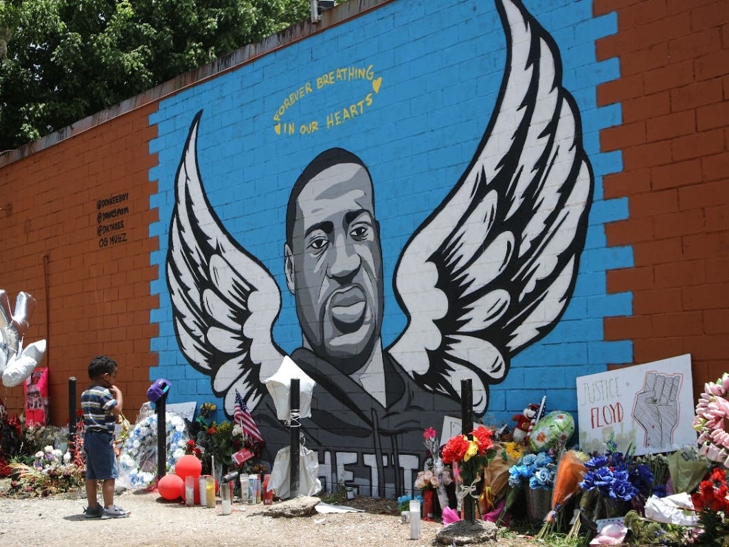 A child views a mural dedicated to George Floyd across the street from the Cuney Homes housing project in Houston's Third Ward, where Floyd grew up and later mentored young men, on June 10, 2020 in Houston.