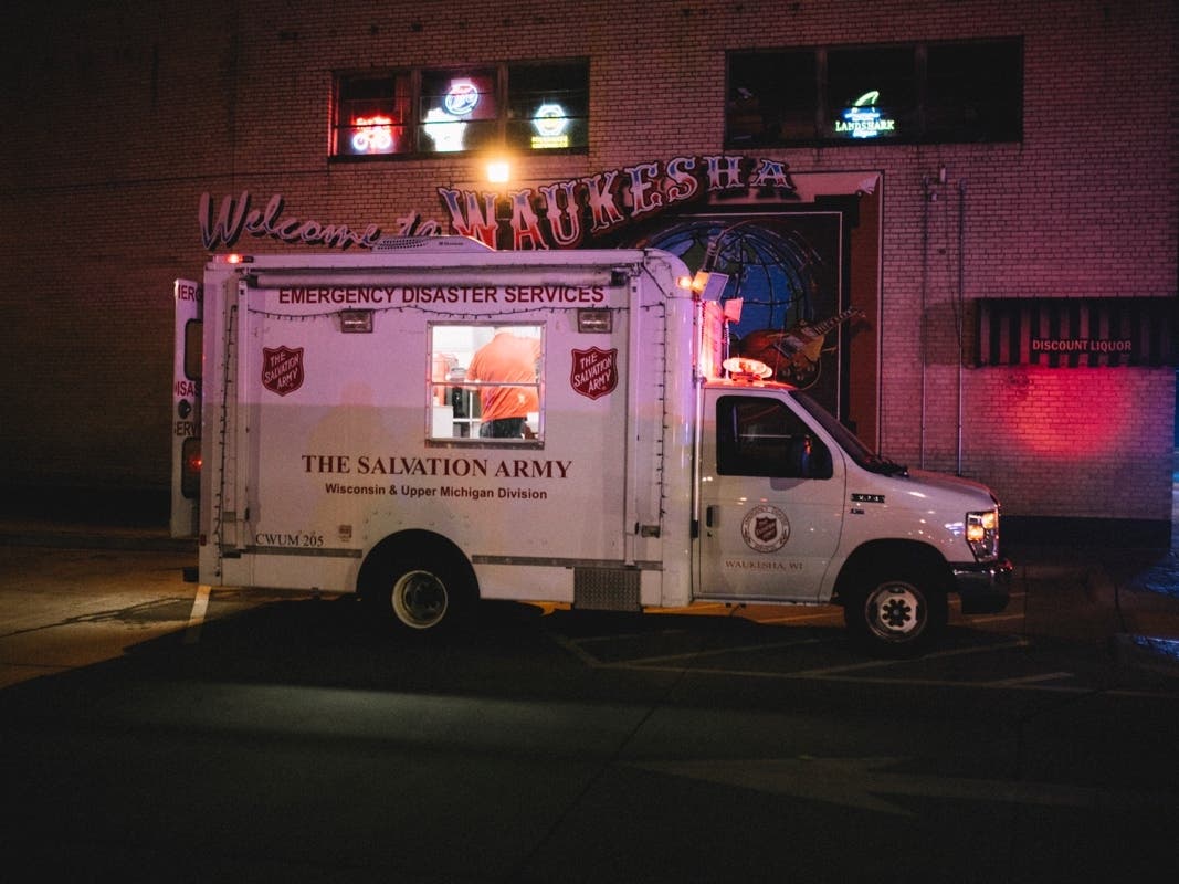 Police and emergency personnel work on a crime scene on November 21, 2021 in Waukesha, Wisconsin. According to reports, an SUV drove through pedestrians at a holiday parade, killing at least one and injuring 20 more.