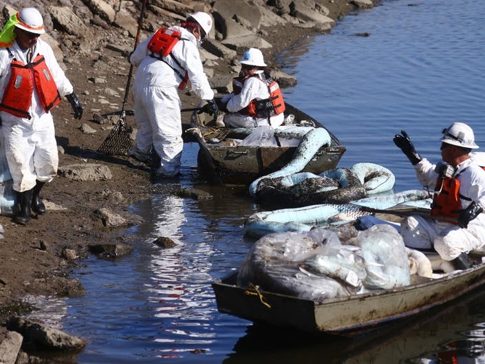 Workers in protective suits clean oil in the environmentally sensitive Talbert Marsh wetlands after an oil spill from an offshore oil platform on October 5, 2021 in Huntington Beach.