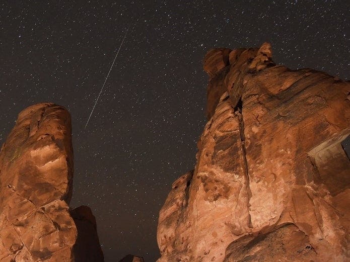 A Geminid meteor streaks across one of the peaks of the Seven Sisters rock formation in Nevada's Valley of Fire State Park in 2018. 