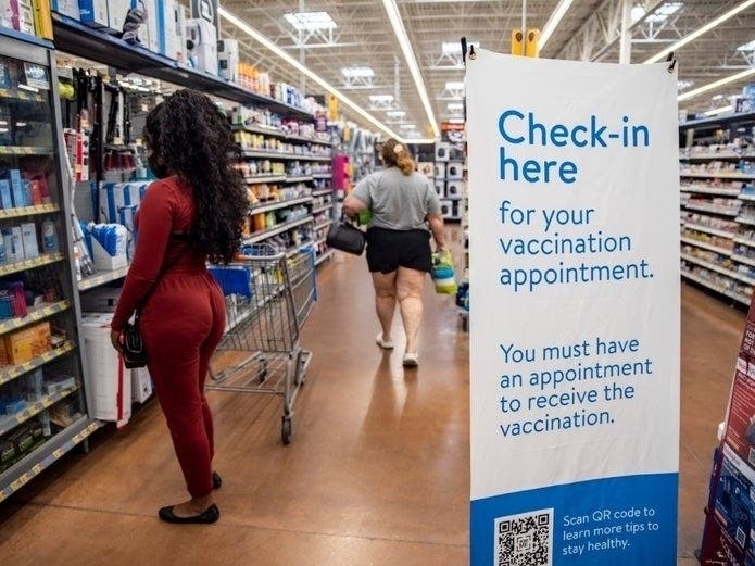Shoppers walk around a COVID-19 vaccine check-in area inside a San Antonio, Texas, Walmart on March 29, 2021. 