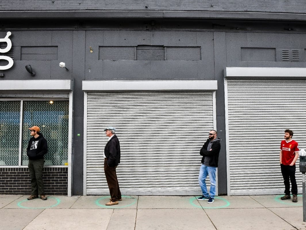 People stand in freshly painted circles 6 feet apart as they wait in a two-hour line to buy marijuana products from Good Chemistry in Denver, Colorado.