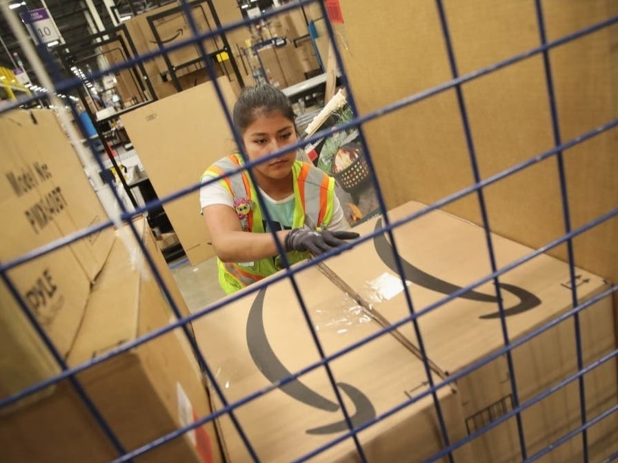 Workers pack and ship customer orders at an Amazon fulfillment center in Romeoville, Illinois. The e-commerce giant announced Tuesday it is postponing Prime Day 2020 in the U.S. 