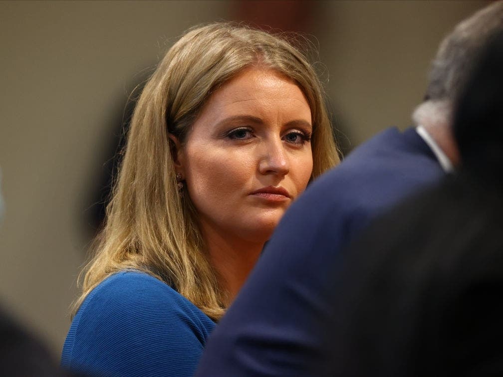 Jenna Ellis, a member of U.S. President Donald Trump's legal team, listens to Detroit poll worker Jessi Jacobs during an appearance before the Michigan House Oversight Committee.