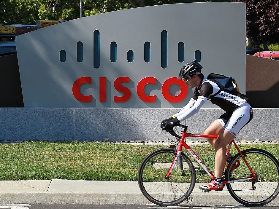 A bicyclist rides by a sign that is posted in front of the Cisco Systems headquarters on August 10, 2011 in San Jose, California.