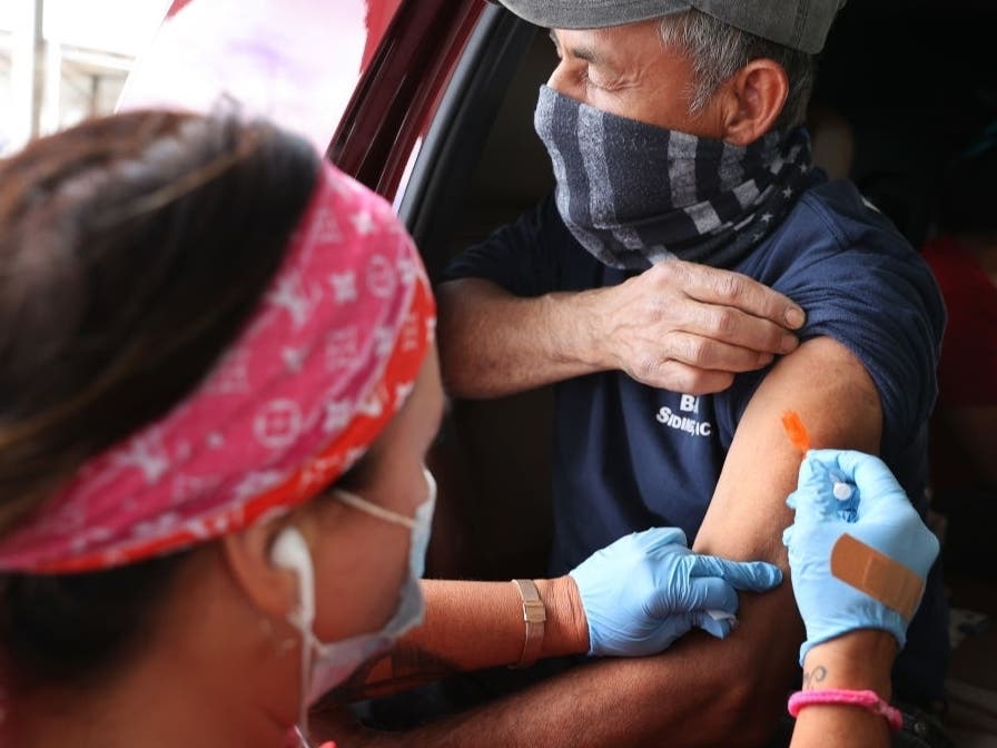 A man receives his first dose of the Pfizer vaccine against the coronavirus at the mass vaccination site at Ripken Baseball on May 5 in Aberdeen, Maryland. State and local governments are offering unique incentives to entice residents to get vaccinated.