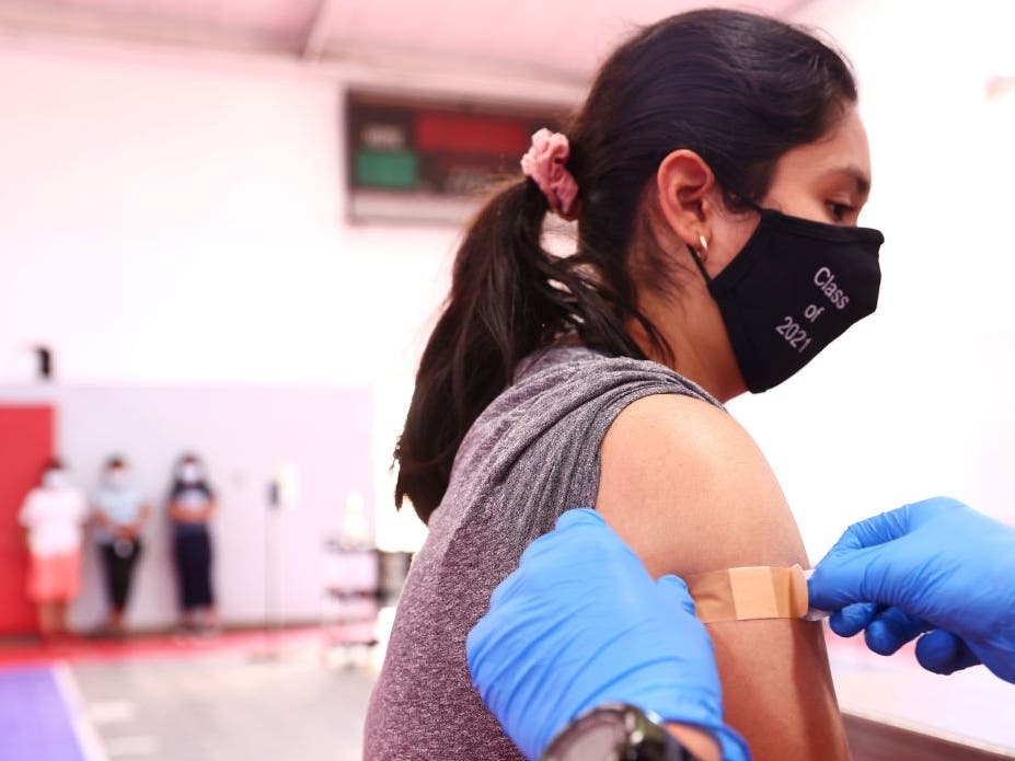 A student wearing a class of 2021 face mask is bandaged after receiving a vaccine dose during a pop-up COVID-19 vaccination clinic Tuesday at James Jordan Middle School in Winnetka, California.