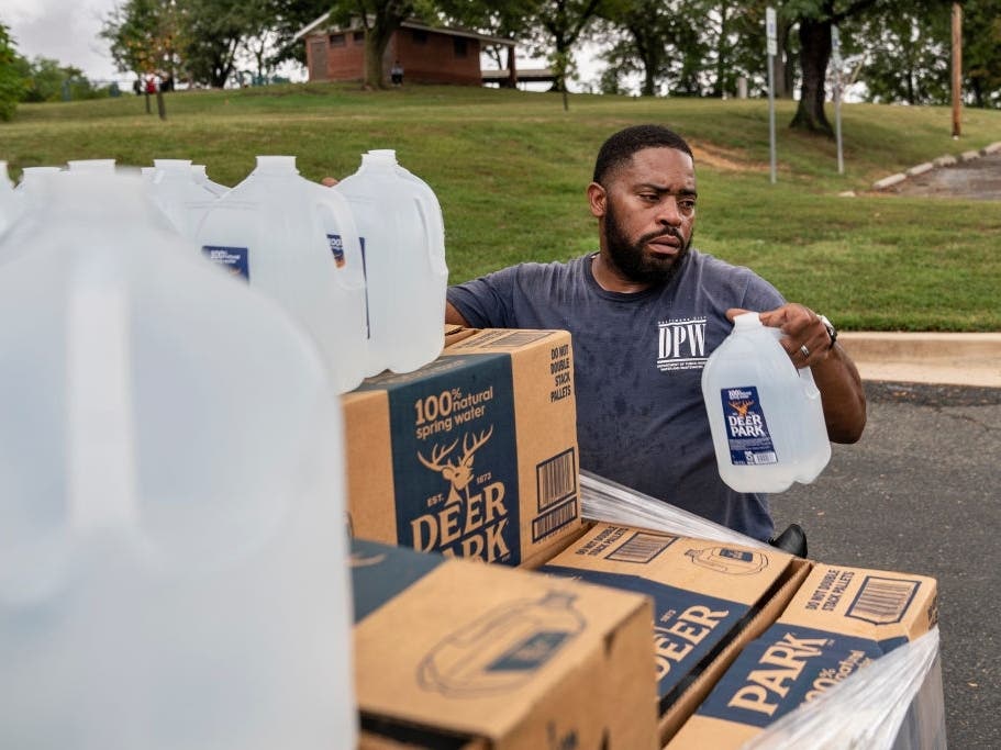 Workers with the Baltimore City Department of Public Works distribute jugs of water to city residents at the Landsdowne Branch of the Baltimore County Library on Sept. 6.