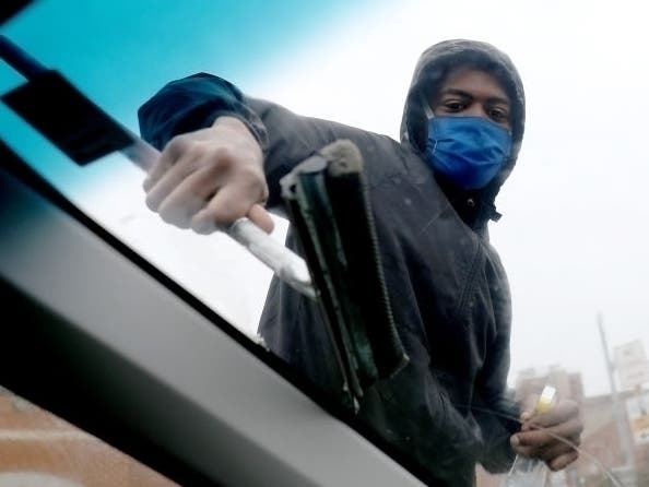 A "squeegee kid" wears a mask while washing a windshield in Baltimore, which as of April 22 has 1,602 cases of the new coronavirus, the fourth most of any jurisdiction in the state. Prince George's, Montgomery and Baltimore counties have the most cases.