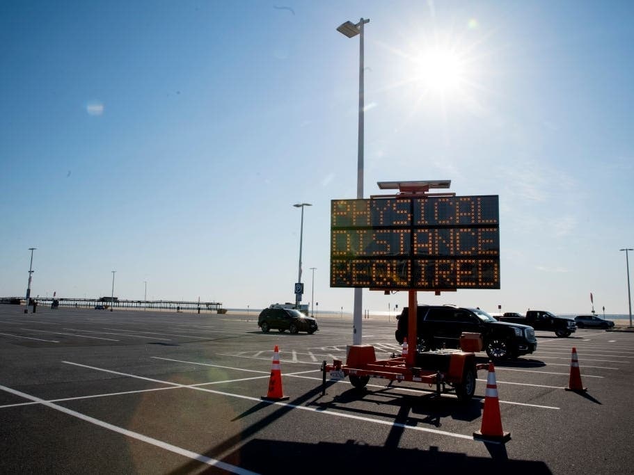 An electric sign displays mandatory physical distancing in Ocean City, Maryland, which lifted short-term rental restrictions Thursday, May 14.