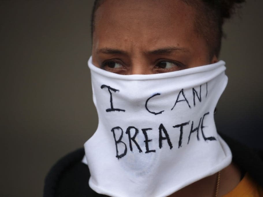 A person wears a mask that reads "I CAN'T BREATHE" as demonstrators continue to protest the death of George Floyd.