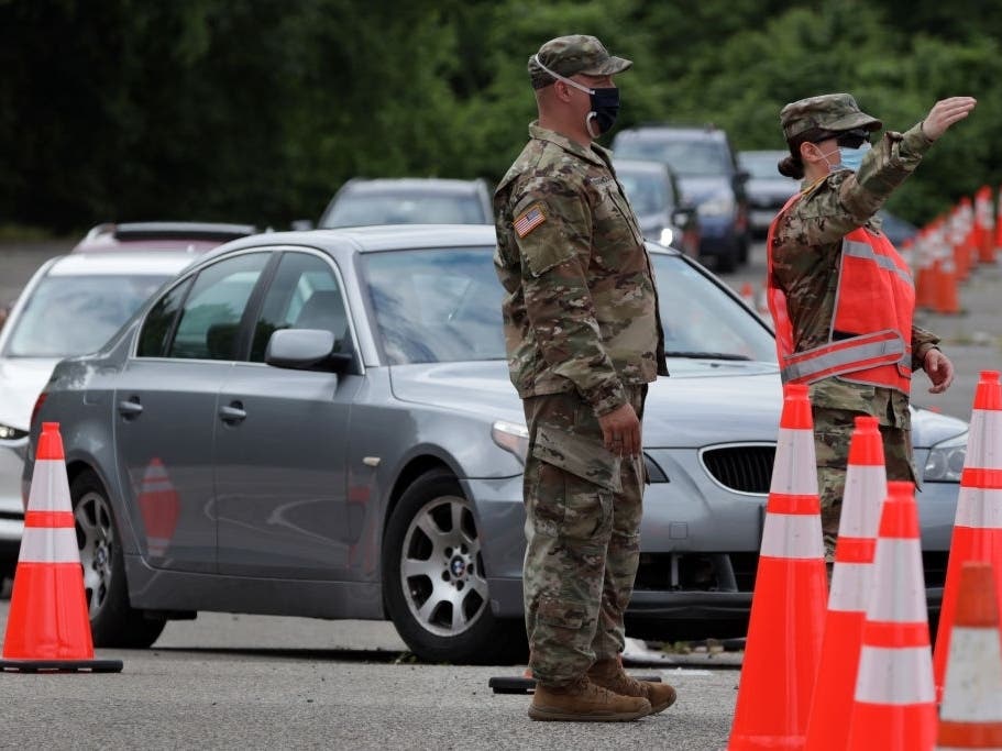 Members of the Maryland National Guard guide traffic at a coronavirus drive-thru testing location at Six Flags America May 29 in Bowie.